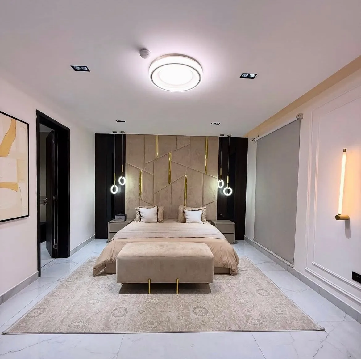 Master suite with geometric padded headboard and gold pendant lights