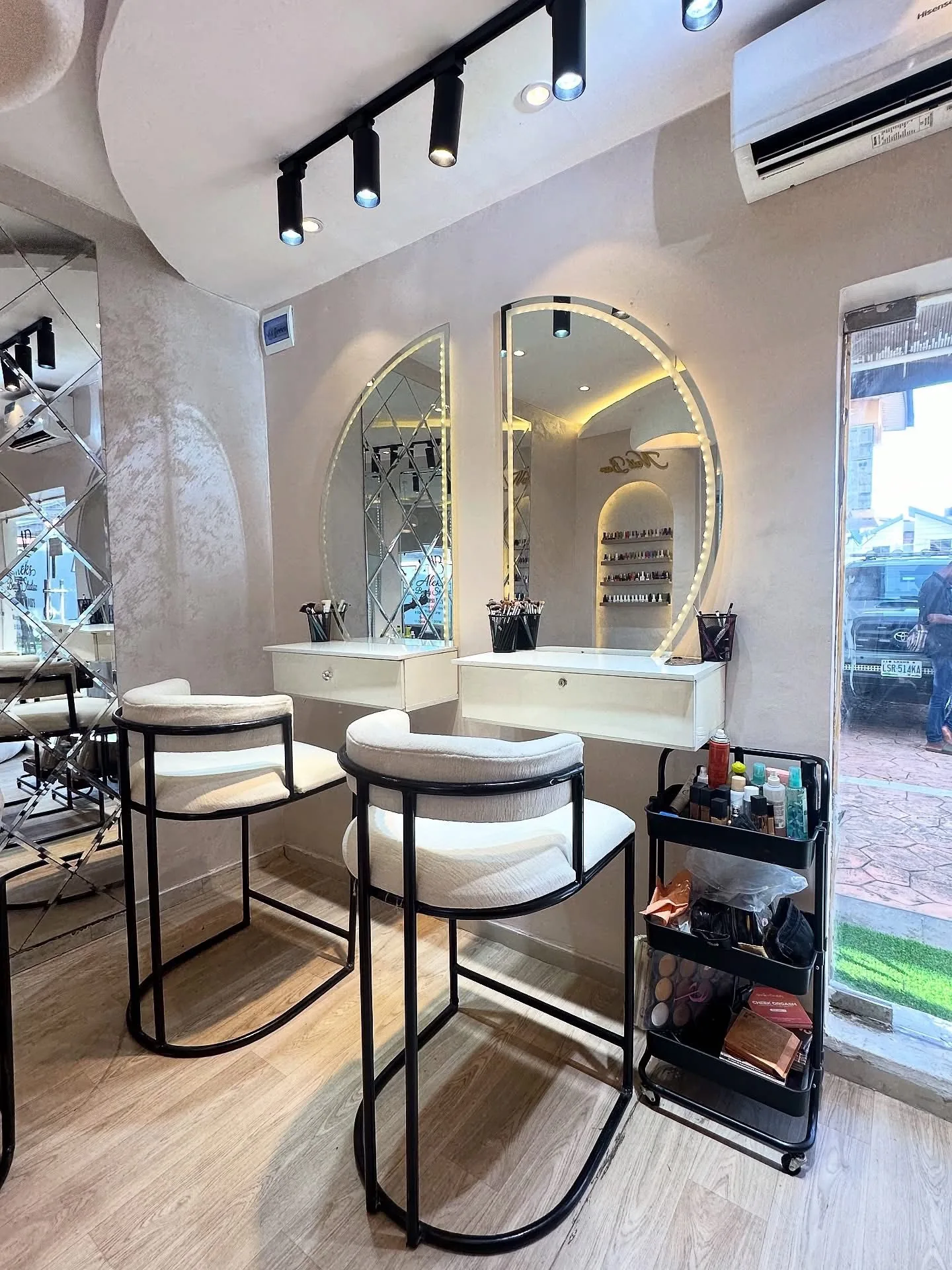 Backlit styling mirrors and plush white bouclé seating